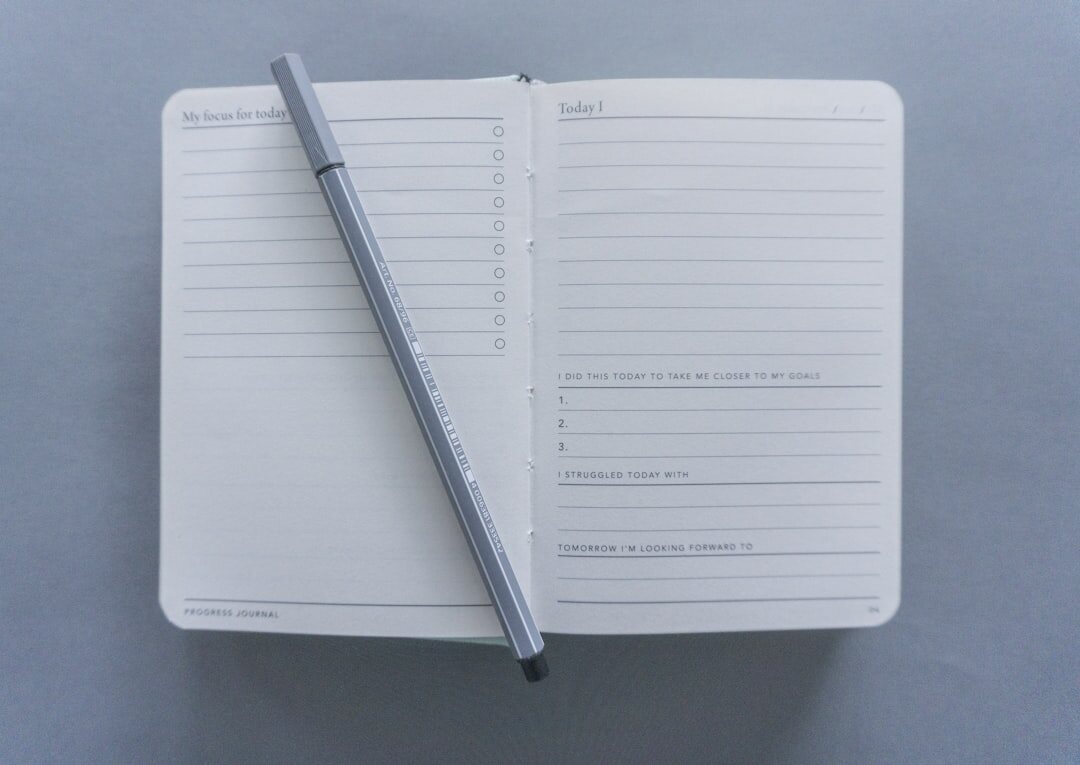 Open notebook with an editorial planning schedule and a pen